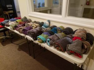 40 hand-knit hats and scarves laid out for the Turpin Cares event