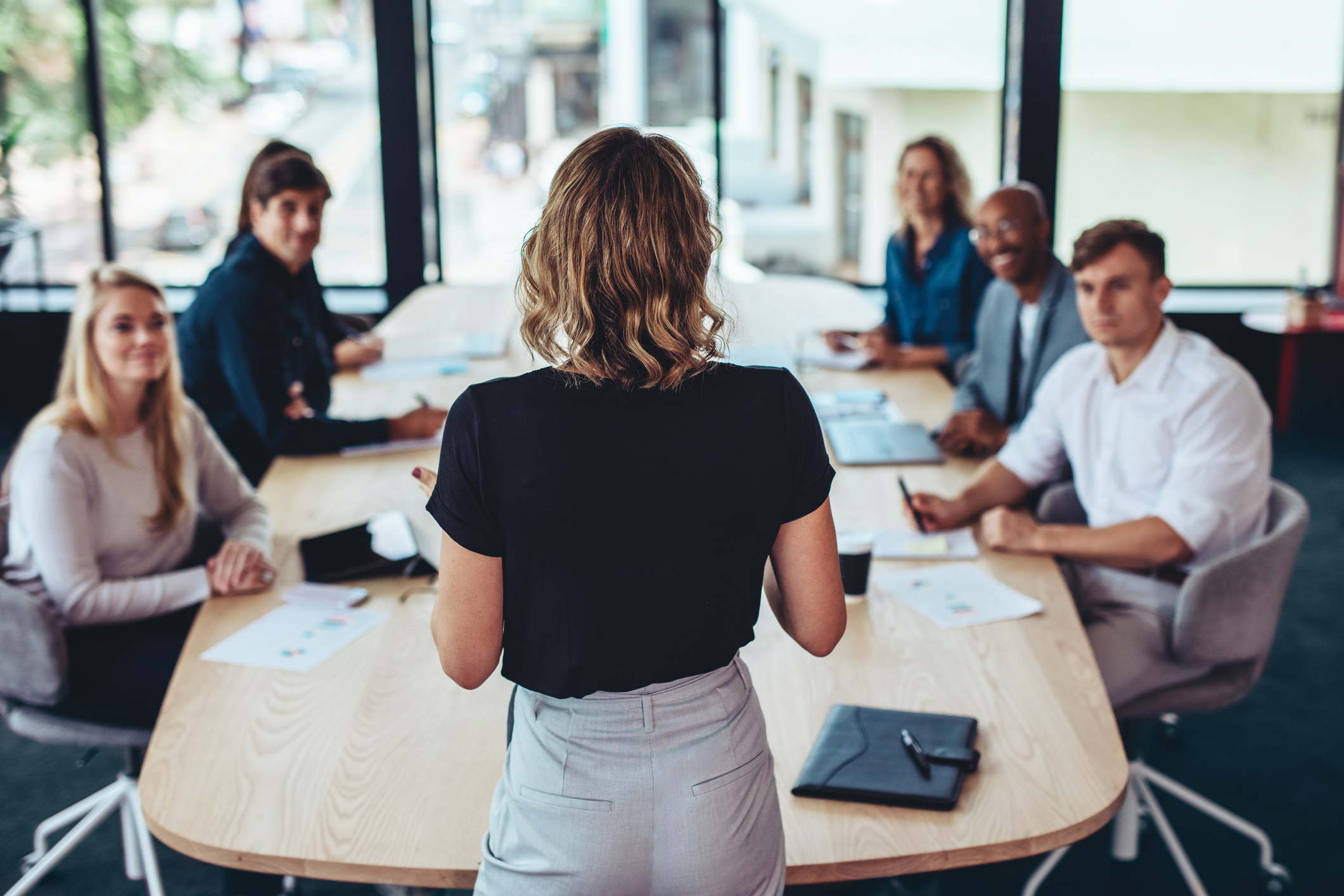 A woman faces co-workers during a business presentation