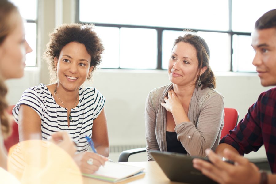 A young woman uses emotional intelligence during a staff meeting