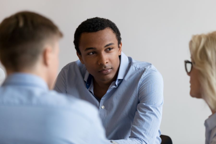 Man intently listening to his two colleagues during a meeting