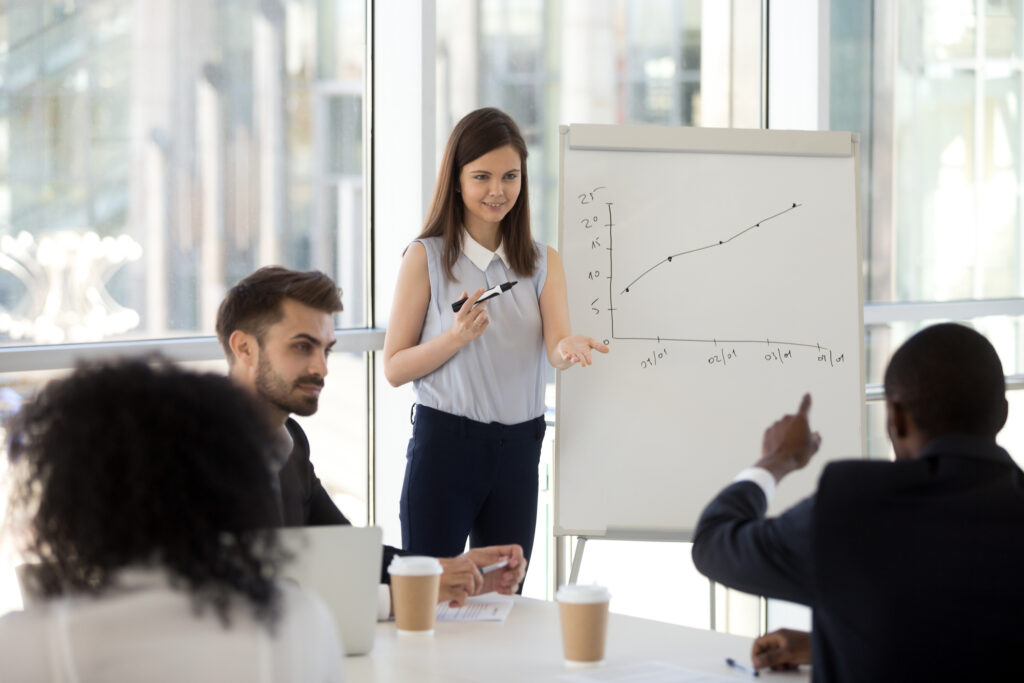 Business presenter engaging colleagues in an interactive discussion during a meeting.